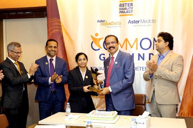 Dr. Azad Moopen awarding a person of determination working with Aster DM Healthcare